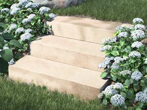 Muurblokken kalksteen Camino Sand met bloemen en struiken