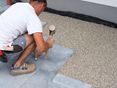 Man legt arduinen platen in een bed van steenslag
