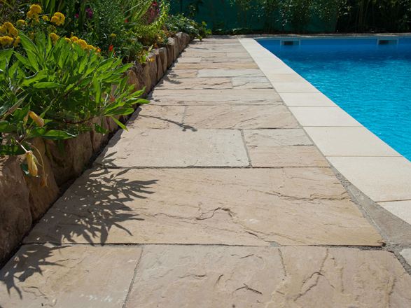 Pad bij het zwembad met Yellow Mint zandstenen platen en tuinbed