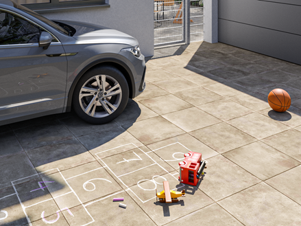 Oprit met Roma 3cm betonlook platen met auto en speelgoed