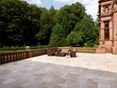 Zonnig terras met vrij uitzicht op het platteland Groot terras met middelgrote travertinplaten en bos op de achtergrond