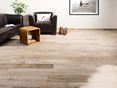 Die Feinsteinzeugfliese Indie Sky ist die perfekte Ergänzung zu einem modernen Einrichtungsstil! Zithoek met kleine houten bijzettafel en houtlook porcellanato tegels op de vloer