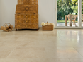 Harmonieuze beige tinten: kalksteentegel Cleopatra Light (klantenproject) Antieke houten kast op lichtgekleurde kalkstenen tegels Cleopatra Light, op de achtergrond zicht op het terras en de tuin
