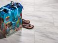 Calacatta tegels met kleurrijke strandtas en sandalen