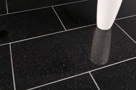 Een witte vaas op zwarte granieten tegels met lichtgekleurde voegen