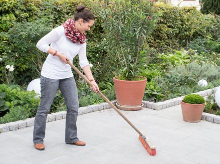 Vrouw maakt graniet grijs terras schoon