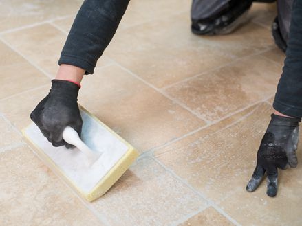 Tegelzetter reinigt de travertin vloer na het leggen